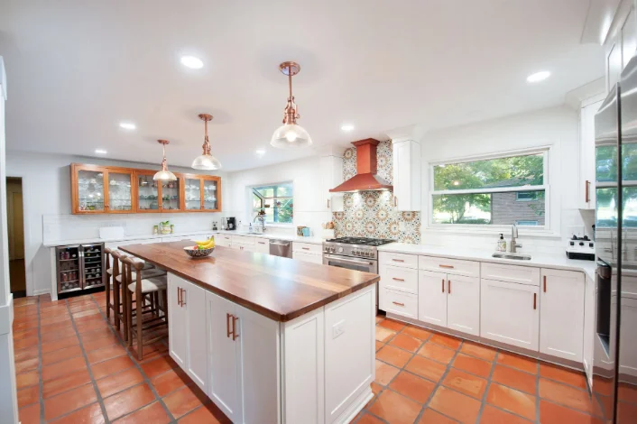 A remodeled kitchen with white cabinets
